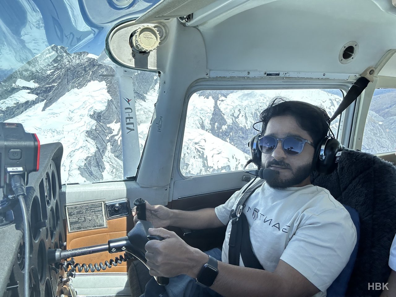 Naveed in the cockpit with mountain scenery outside