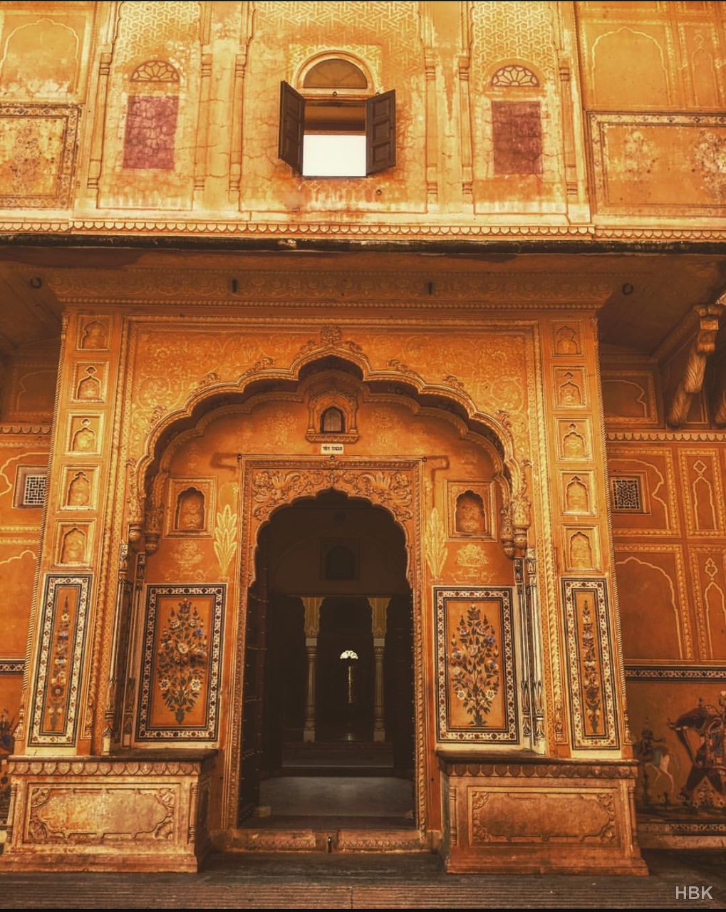 Ornately decorated golden facade with an arched doorway