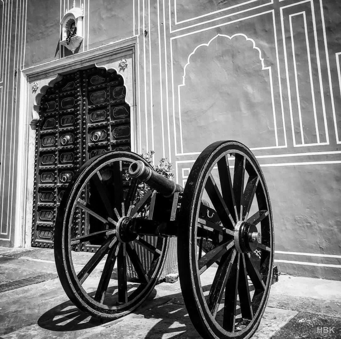 Black-and-white photograph of a cannon beside an ornate doorway