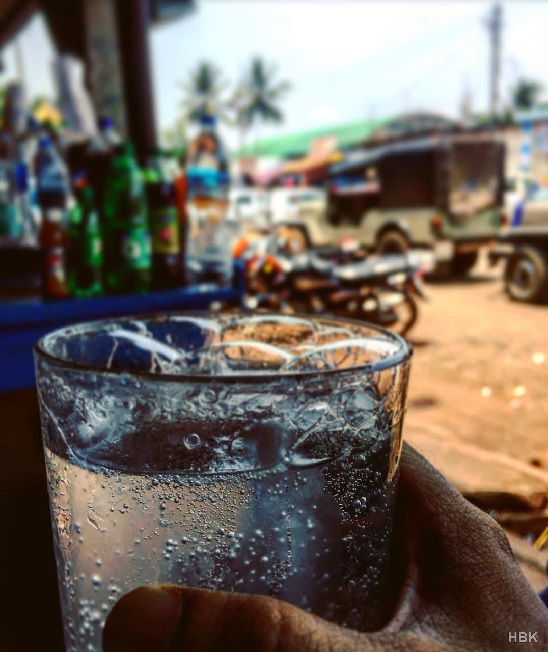 Glass of sparkling water with a busy street softly blurred behind it